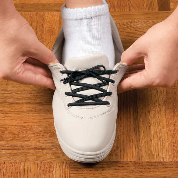 Picture of a person stretching a shoe tied with elastic shoe laces, showing how the laces stretch.